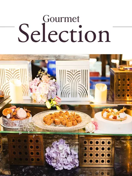 A gourmet dessert selection beautifully arranged on a multi-level display with decorative lanterns and floral accents, perfect for adding a sweet, sophisticated touch to any event.