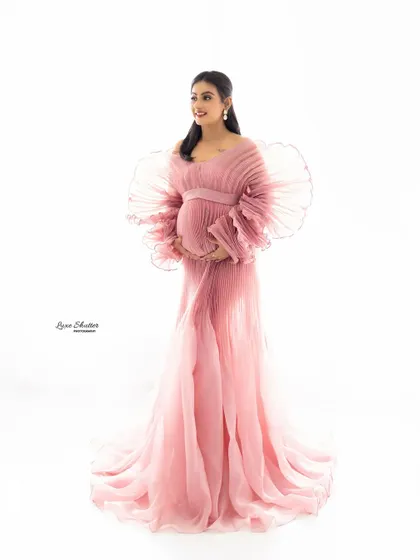 This custom-designed pink pleated gown is a true showstopper. Its delicate texture and ethereal quality are perfect for creating soft, graceful, and unforgettable maternity portraits.