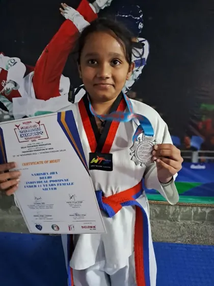 A student with her silver medal in the sub-junior Poomsae category at the Aryan's Cup.