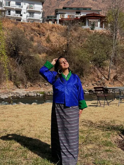 Wearing a traditional Kira in Bhutan, I felt a deep connection to the culture and the serene landscape. Moments like these, soaking in the sun by the river, are what I bring back to my studio.