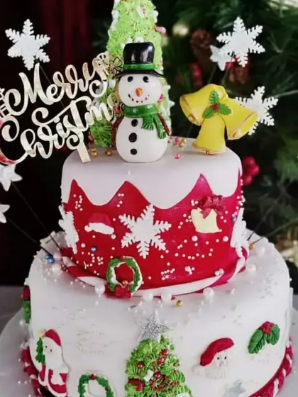 This two-tier Christmas cake is full of festive cheer, featuring a snowman, snowflakes, and Christmas trees. It’s a showstopper for any holiday party.