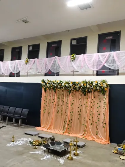 A wider view of the anniversary celebration hall, showing the main stage backdrop and coordinating fabric draping along the upper balcony for a complete, unified look.