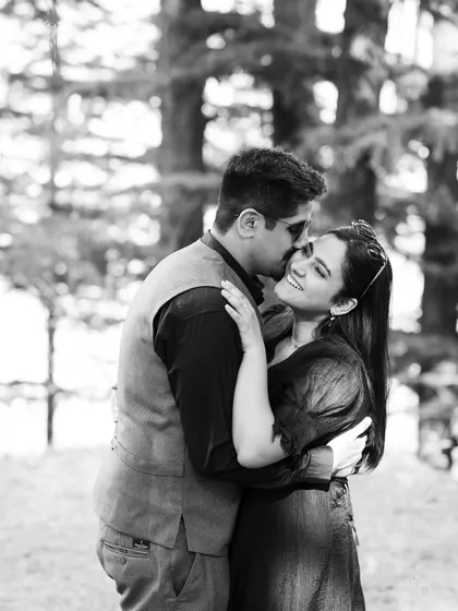 A timeless black and white photo of a sweet kiss on the cheek. This candid moment is full of affection and warmth.