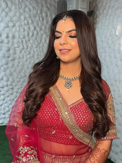 The final look, ready for the wedding. Her hair is styled in soft waves, and her makeup is glowing and radiant.