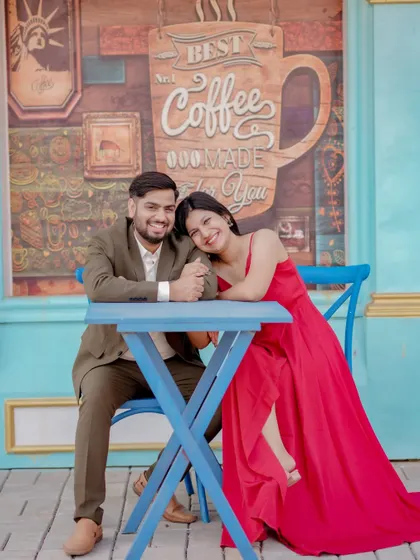 A cozy and romantic moment at a cafe-themed set. The couple's intimate pose and the charming background create a sweet, story-driven image perfect for their pre-wedding album.