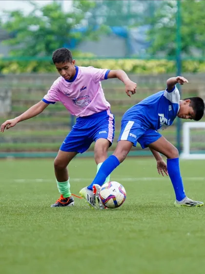 A player from Pune's Loyola School shields the ball from a BFC youth player. These cross-team matches provide valuable experience.