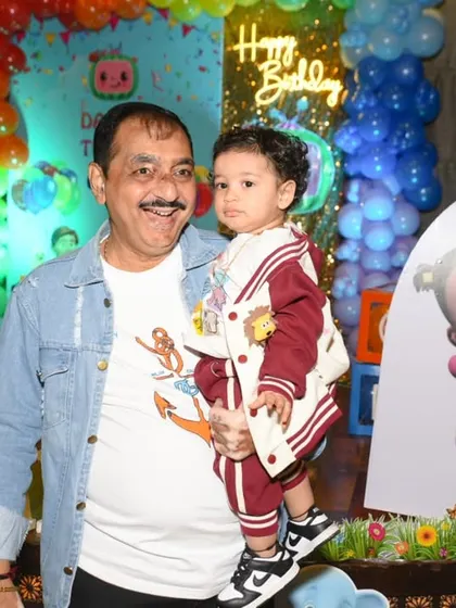 A grandfather and grandson share a special moment at the first birthday party.