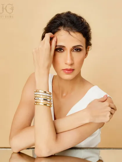 Understated sophistication. These stacked gold and silver bracelets complement your natural grace, offering a modern and chic way to adorn your wrist.