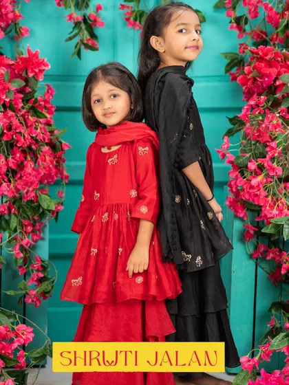 Bold and beautiful. These sisters make a statement in matching red and black sharara sets. The tiered design and delicate embroidery create a look that is both dramatic and elegant, perfect for a sangeet or wedding reception.