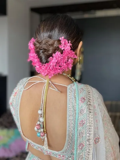 A close-up of the floral wedding bun, highlighting the texture of the bun and the freshness of the flowers.