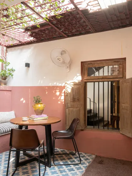 The outdoor patio of my studio, a quiet corner for a cup of coffee. We used a mix of materials, including patterned tiles and a simple built-in bench, to create a space that feels like a natural extension of the restored building.