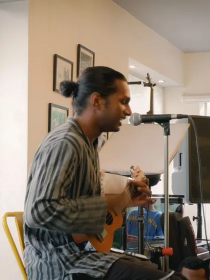 A musician playing the ukulele and singing, bringing a light and joyful vibe to the room. We welcome artists with all kinds of instruments and styles.