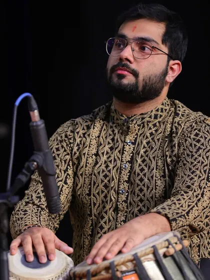 On stage, fully immersed in the performance. The intricate patterns on my kurta mirror the complex rhythms I create on the tabla, weaving a rich tapestry of sound.