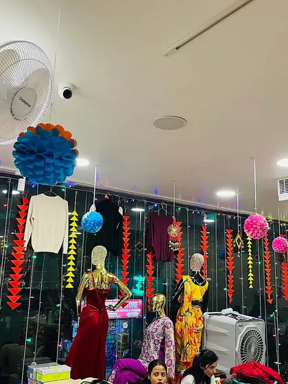 A view of the store's window display area, decorated with colorful paper pompoms and hangings.