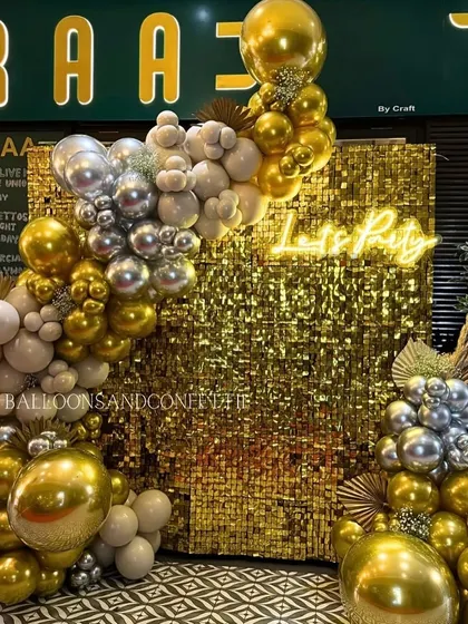 A full view of our gold and silver shimmer wall setup at the restaurant Dobaraa. The organic balloon arch in neutral, gold, and silver tones adds a touch of modern elegance to the party decor.