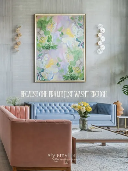 A closer look at the pastel-toned living room, where a soft pink sofa and a tufted powder blue sofa create a playful yet sophisticated color story. The large floral artwork ties all the elements together.
