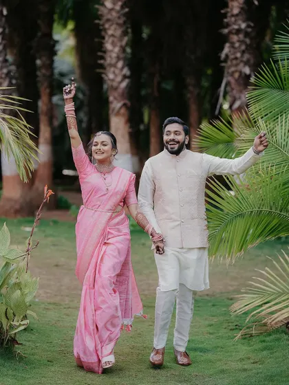 That "we did it" feeling. A celebratory shot of Omkar and Rhutuja walking through a garden after their engagement, full of happiness.
