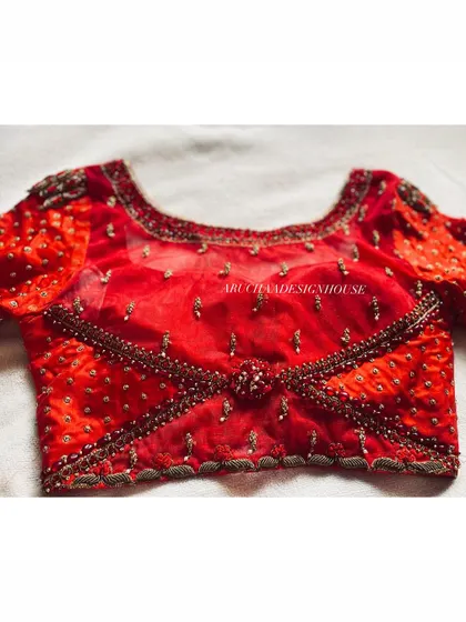 The front view of the red wedding season blouse, showing the criss-cross pattern created with beadwork and a central embellished motif.