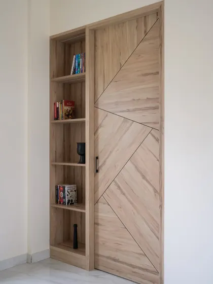 This is a hidden door designed to look like a seamless part of the wall paneling. When closed, the geometric pattern continues across the surface, completely camouflaging the entrance to the next room.