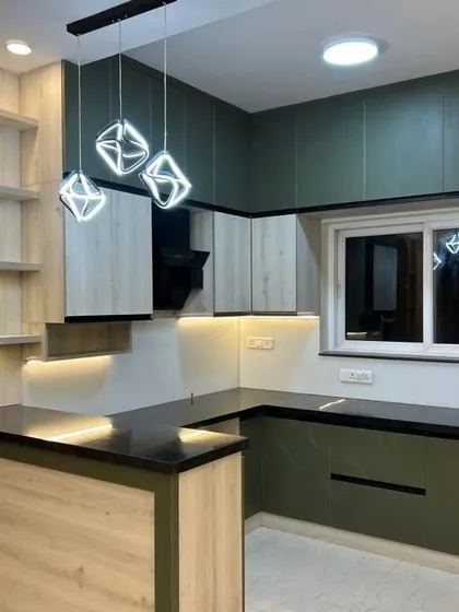 Another view of the open kitchen, showing the U-shaped layout and the stylish breakfast bar. The under-cabinet lighting provides excellent task lighting.