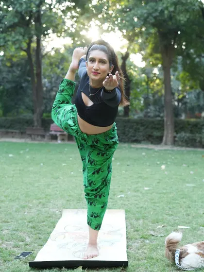 Finding my balance with Natarajasana, the Lord of the Dance pose, in a local park. My little dog often joins me for my personal practice outdoors.