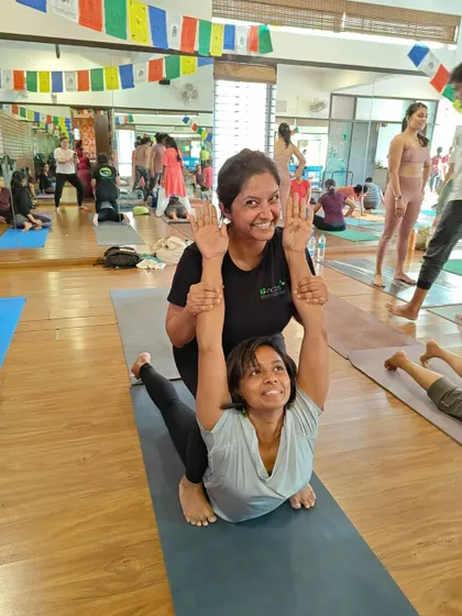 This assisted backbend helps a student go deeper into Bhujangasana (Cobra Pose). The partner provides gentle support to lift the chest and open the heart.