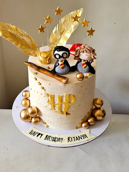 Another angle of the Harry Potter cake, showing the arrangement of the handmade figurines and golden snitch-like details.
