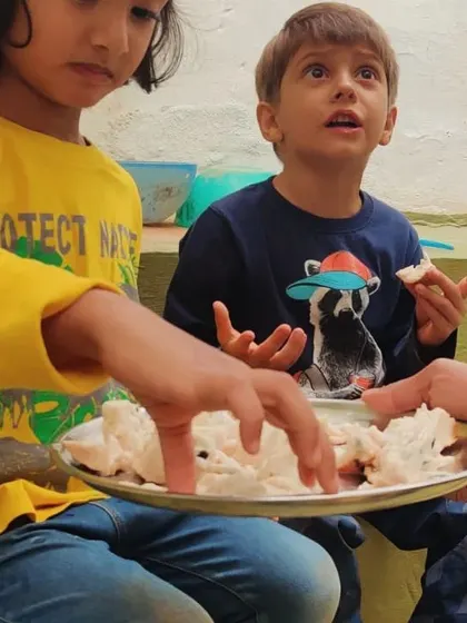 Success! The harvested fruit is shared among the children, a sweet reward for their ingenuity and teamwork.