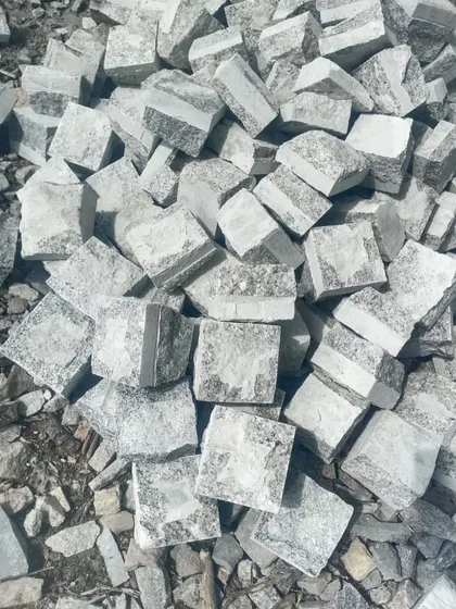 A close-up of my hand-cut grey cobblestones, showing their natural texture and shape.