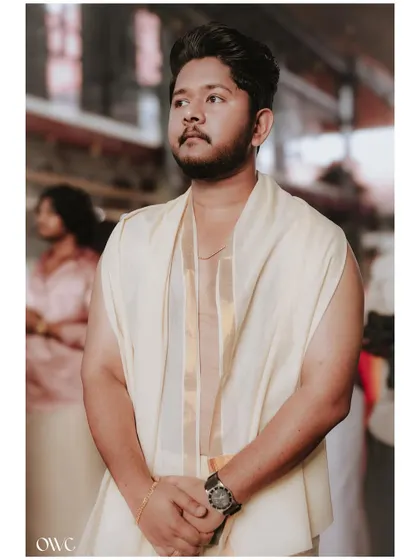 A handsome portrait of the groom in his traditional wedding attire, captured in a moment of thought.
