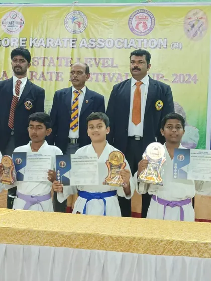 More winners from the Mysore Dasara Karate Championship, standing with officials after receiving their awards for their excellent performance.
