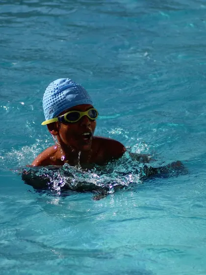 A young learner enjoying his time in the water during a swimming lesson.