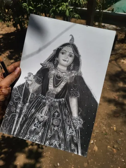 Holding the finished Radha Rani sketch outdoors. The natural light brings out the subtle shading and delicate line work.