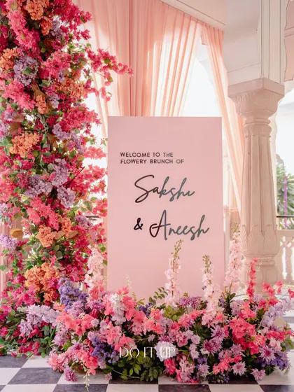 The welcome sign for the 'Flowery Brunch,' framed by a stunning pillar of colorful bougainvillea and other blooms. This created a grand and unmissable entrance moment.