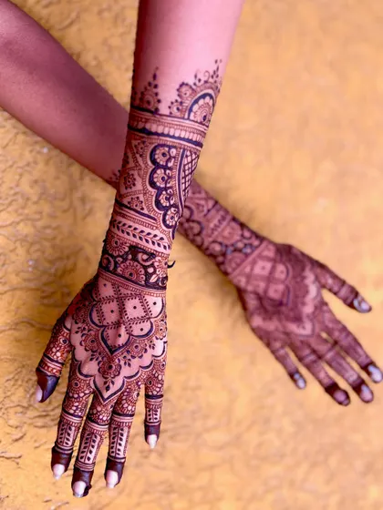 An artistic, angled shot of the bridal mehendi, emphasizing the design's flow and length.
