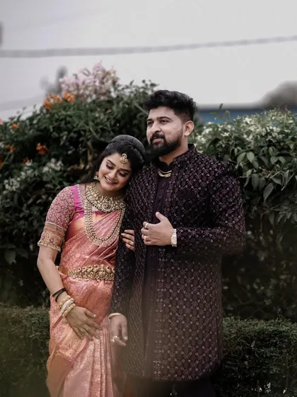 A candid, happy moment captured in a garden setting. The couple's relaxed smiles and body language show their easy comfort with each other.