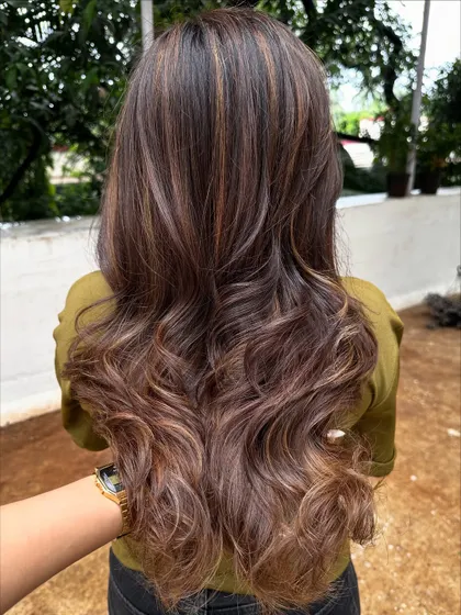 Getting her 'Vacay Hair' on with these beautiful ribbon highlights. This technique creates a gorgeous, flowing look that’s perfect for showing off on your next trip.