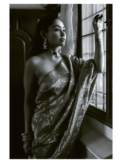 A black and white shot of the woman looking out a window, creating a sense of longing and quiet beauty. This is an example of my narrative portrait style.