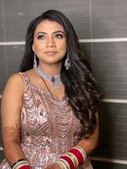 A beautiful princess look for a reception. The hair is styled in soft, open waves, keeping the look glamorous and comfortable for a night of celebration.
