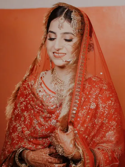 A happy bride smiling under her veil. This candid-style portrait captures a moment of pure joy and anticipation.