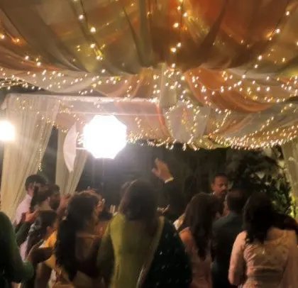 The party continues under the warm glow of the string lights.