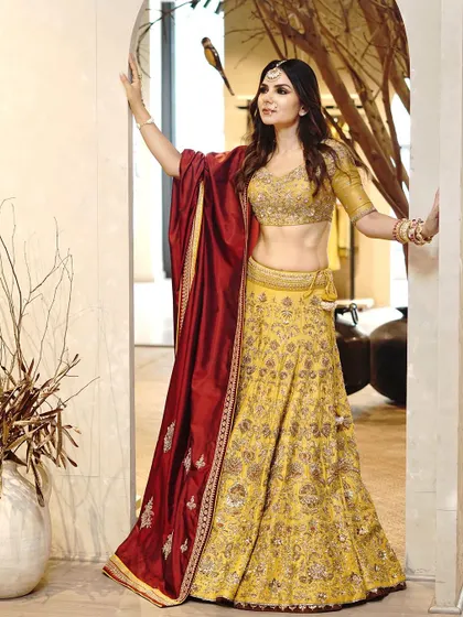 A candid-style shot of a bride in a yellow and red lehenga, capturing a moment of joy. This shows my ability to capture natural emotions during a bridal shoot.
