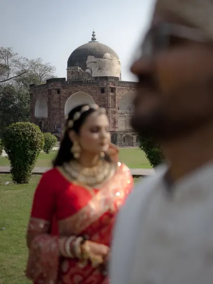 Another artistic use of focus, this time with the groom blurred in the front and the bride in her regal red saree perfectly framed in the background.