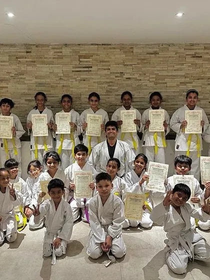 Our youngest karateka from the Prestige Falcon City dojo are thrilled after their very first belt exam, proudly holding their hard-earned yellow belt certificates.