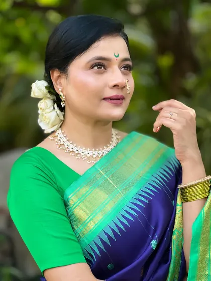 Actress Bhargavi Chirmuley looking serene and beautiful for the music video. Her look features a classic updo with white roses and a traditional nath.