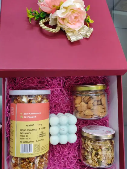 Another variation of the healthy hamper in a red box. This one includes gourmet popcorn, almonds, muesli, and a trendy bubble candle for a modern touch.