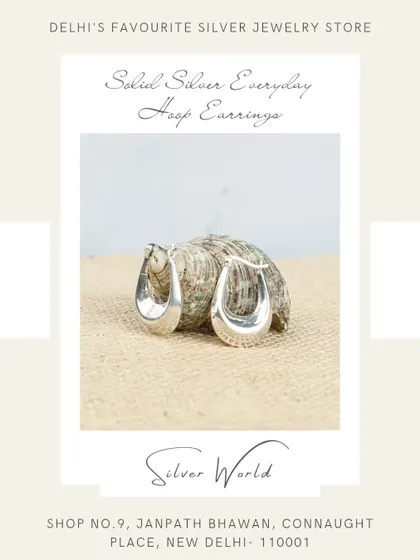 A product shot of our solid silver everyday U-shaped hoop earrings, displayed on a natural jute background to emphasize their simple, clean design.