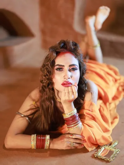A direct and engaging portrait from our 'Hai Rama' series. The model's expression, combined with the traditional bangles and mirror prop, tells a compelling story.