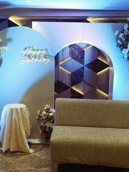 This is a clean and stylish backdrop I created for an adult's birthday party. The design uses modern arched panels, a custom 'Happy Birthday' neon sign, and beautiful floral arrangements, perfect for a sophisticated and contemporary celebration.