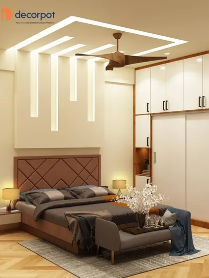 This master bedroom exudes elegance with its geometric-patterned headboard and integrated bedside tables. The false ceiling with recessed lighting adds a soft, ambient glow to the entire room.